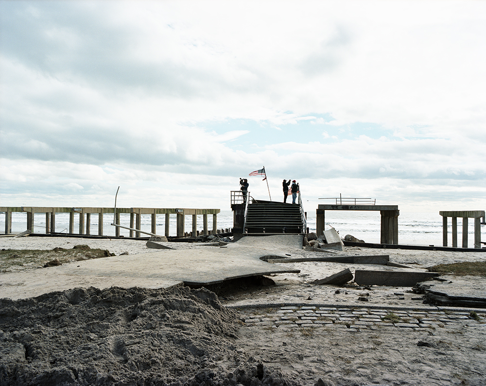 Susannah Ray<br /> <em>Flag Over Boardwalk Remnants, Rockaway Beach, NY, October</em>, 2012<br /> Digital C-prints<br /> 24 x 30" &nbsp; &nbsp;Edition of 10<br /> 40 x 50" &nbsp; &nbsp;Edition of 5